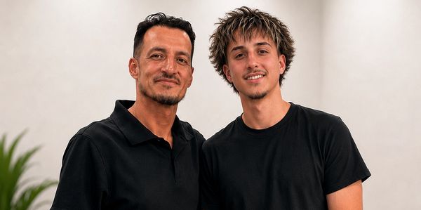 Two men smiling together indoors.