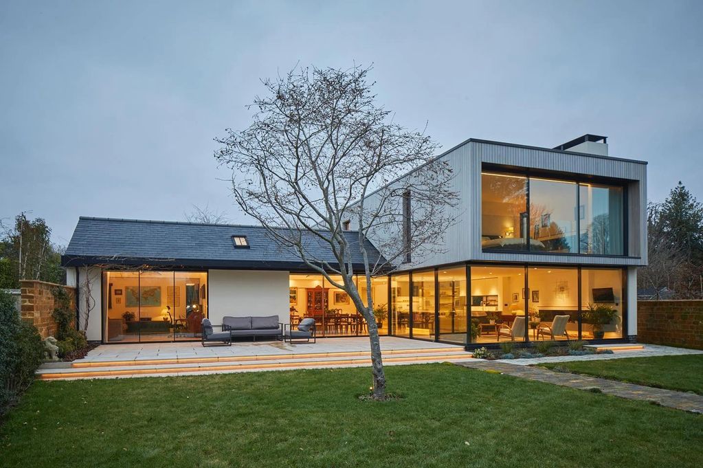 Modern house with large windows and a garden.