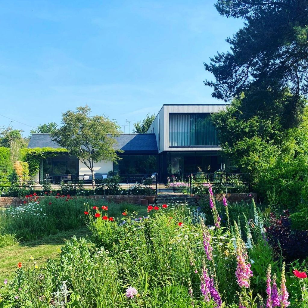 Modern house with a vibrant flower garden in front.