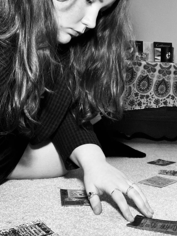 A portrait of the author, posed with a burning candle and a collage.