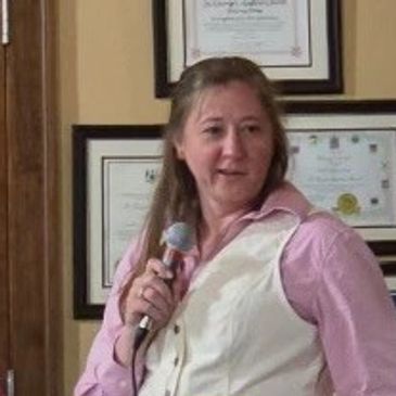 Woman speaking into a microphone during an event.