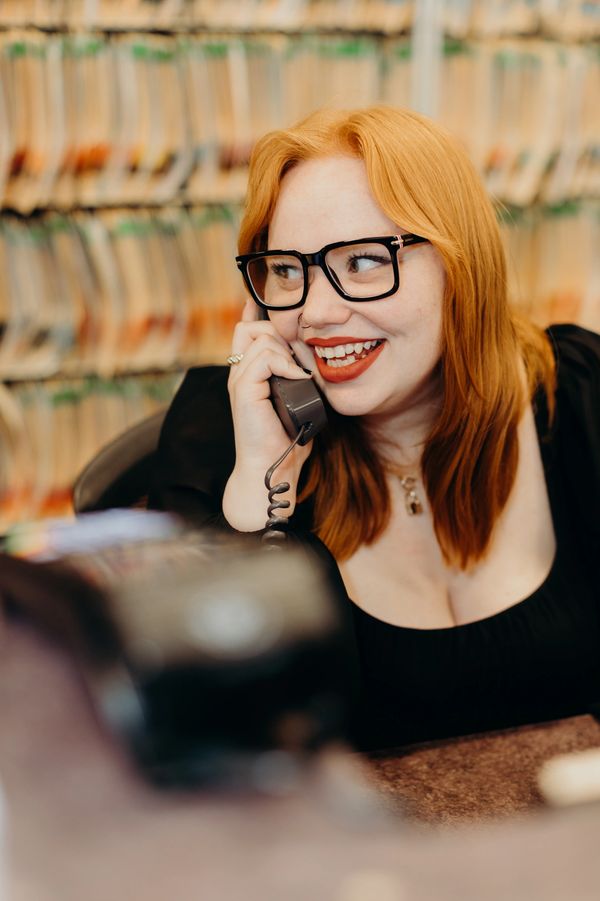 Smiling woman with glasses talking on the phone.