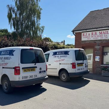  Family butcher vans parked outside a traditional butchers shop.
