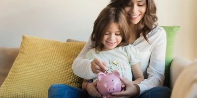 MUMMY AND DAUGHTER WITH PIGGY BANK