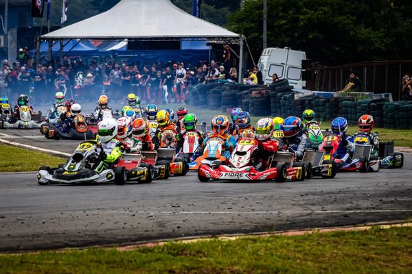 Go-kart race with drivers competing closely on a track.