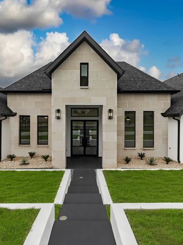 Modern house facade with black roof and symmetrical windows.