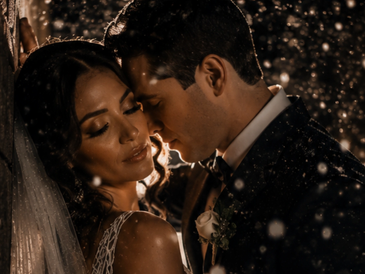 Romantic wedding moment with couple embracing in rain.
