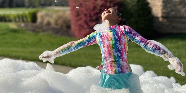 Foam party event in the North Charlotte area with kids running through floating bubbles