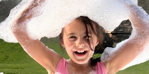 Kids enjoying a foam party in Matthews NC near a pool in a backyard setting 
