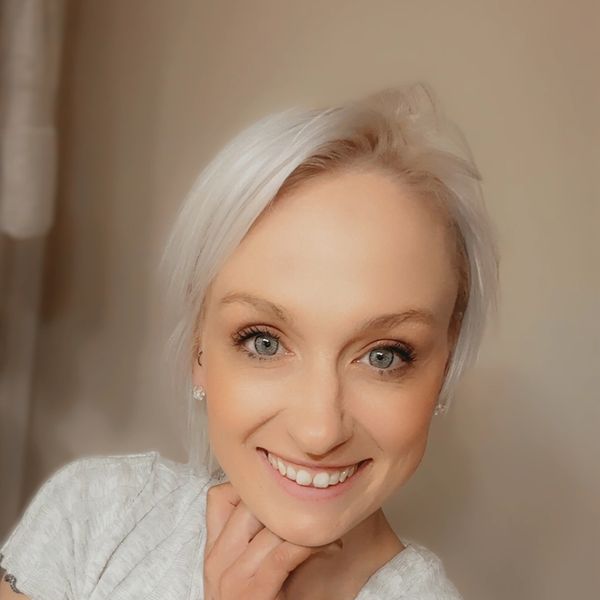 Smiling woman with platinum blonde hair and blue eyes.