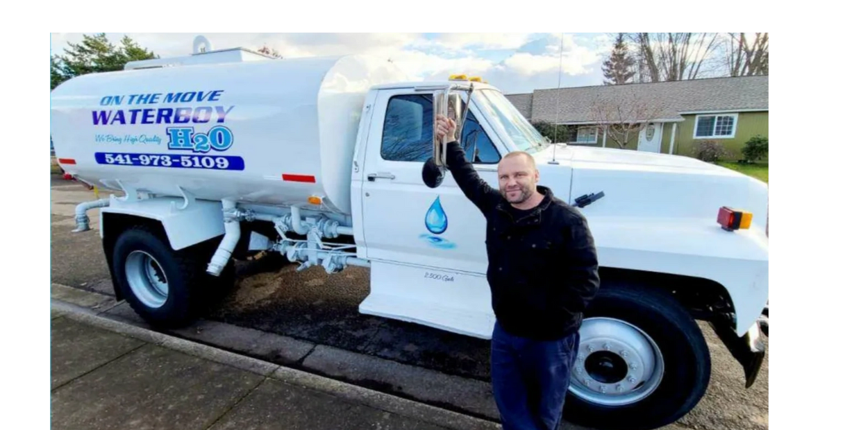 Ryan Traina (Owner of On The Move Water Boy) in front of his water truck. 