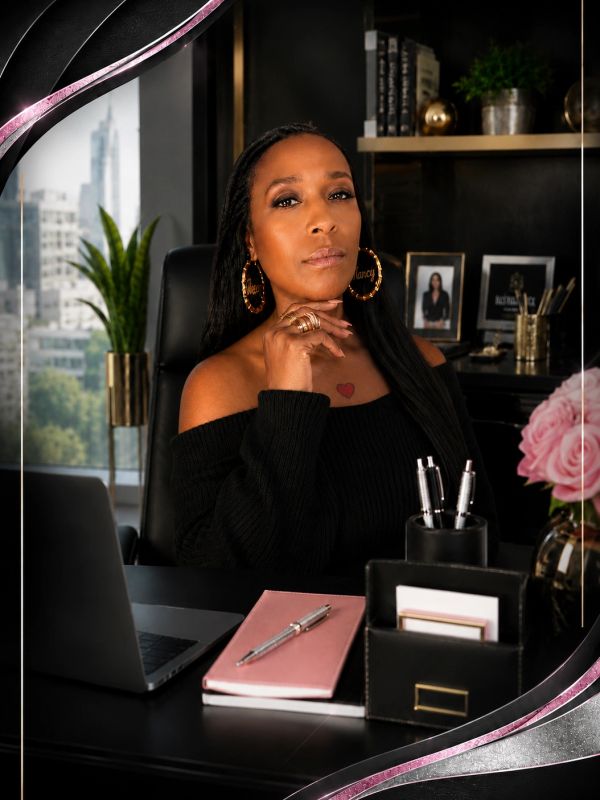 Confident woman sitting at desk with laptop and office supplies.