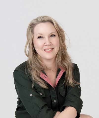 Smiling woman with blonde hair in casual attire.