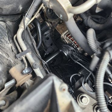 Close-up of a car engine compartment with visible wiring and components.