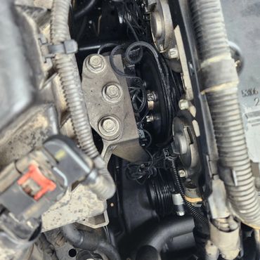 Close-up of an engine compartment showing pulleys and cables.