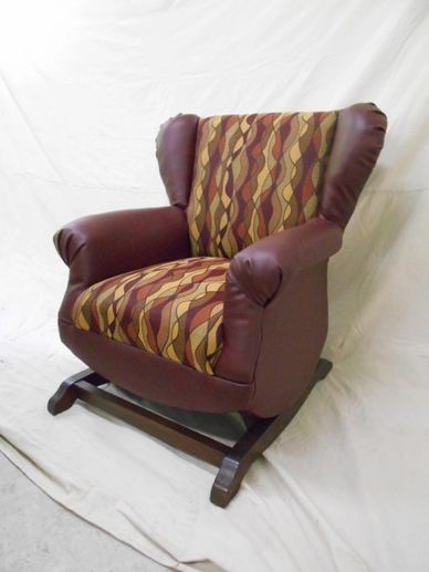 Vintage armchair with patterned fabric and leather sides on a wooden rocker base.