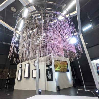 Modern art installation with hanging elements in a gallery space.