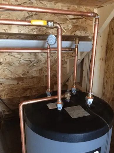 A indirect water heater was installed by water pros showing new copper piping ballvalves and a gauge