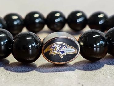 Black beaded bracelet with Baltimore Ravens logo charm.