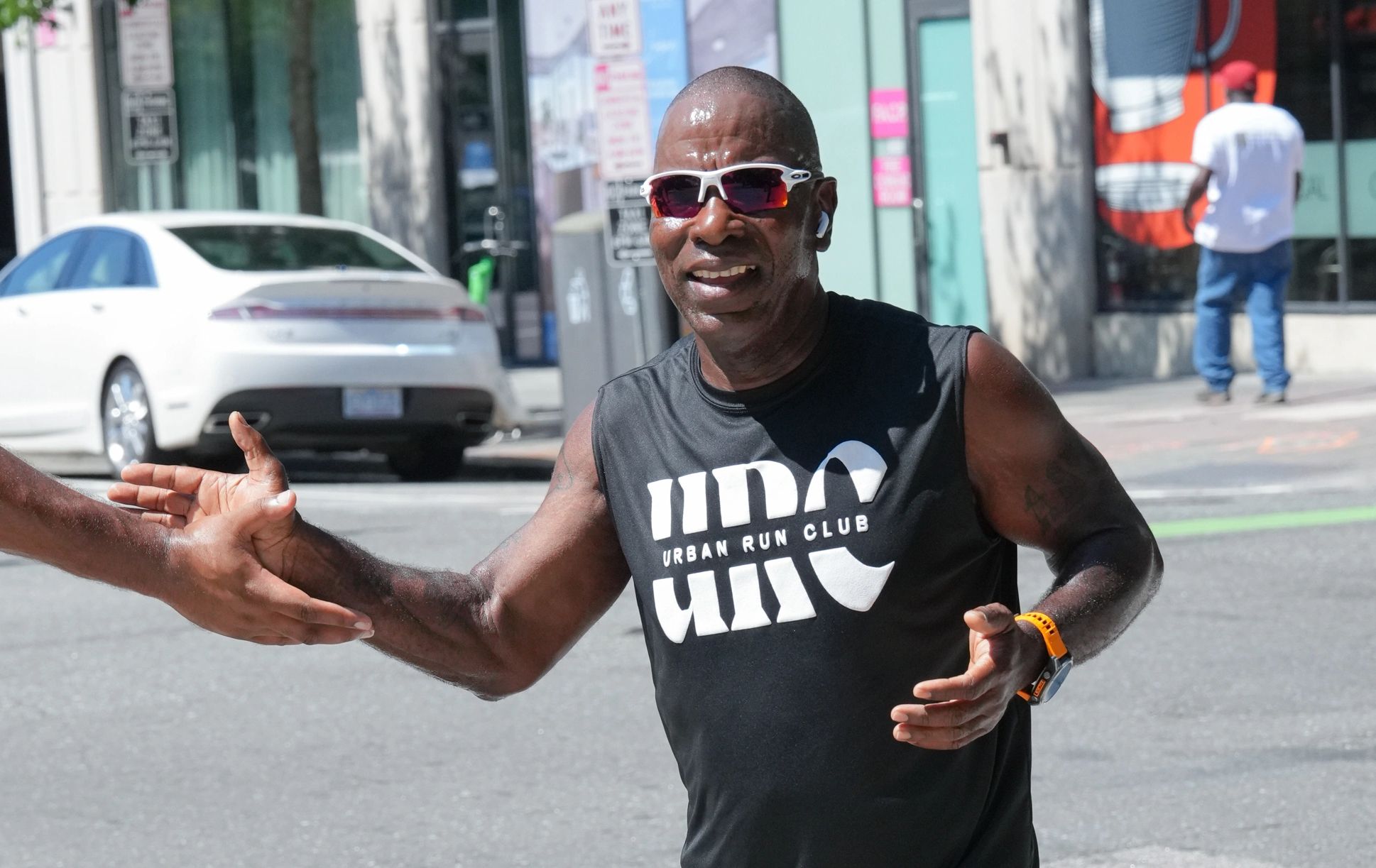 Smiling runner giving a high-five during a race.