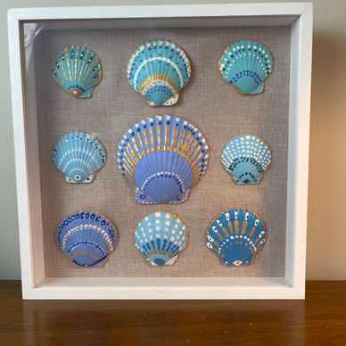 Decorative frame with painted seashells in blue tones.