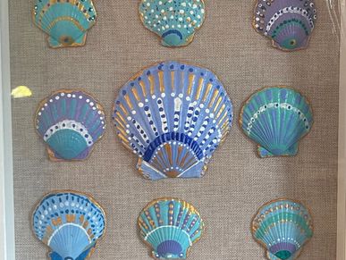 Colorful decorated seashells on fabric background.