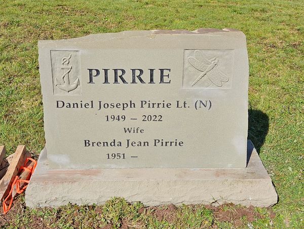 Gravestone of Daniel Joseph Pirrie and Brenda Jean Pirrie in a grassy area.