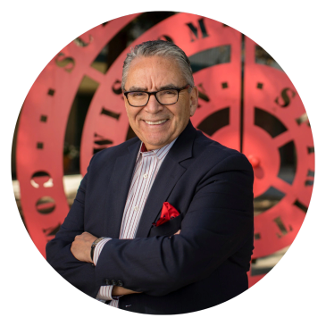 Man in glasses smiling with arms crossed.