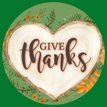 Heart-shaped wood slice with 'Give Thanks' text and autumn foliage.