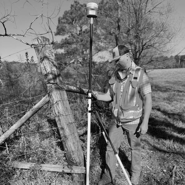 Field Technician collecting project field data for a TX land survey using Trimble GPS Technology