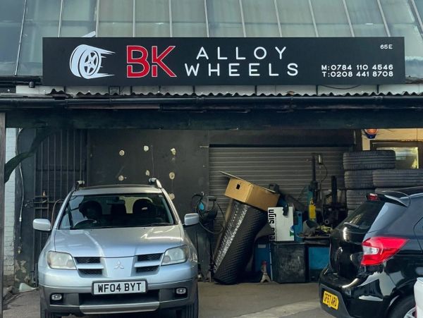 BK Alloy Wheels storefront with two parked cars.