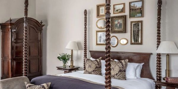 Elegant bedroom with a four-poster bed and classic wooden furniture.