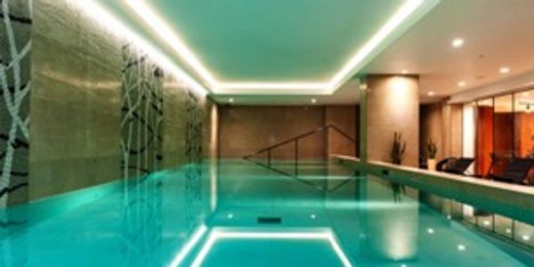 Modern indoor swimming pool with ambient lighting and sleek design.