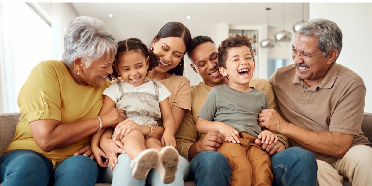 Latino family bonding with children, parents and grandparents together on a sofa. 