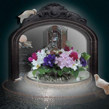 Colorful flowers in front of an ornate mirror with seashells.