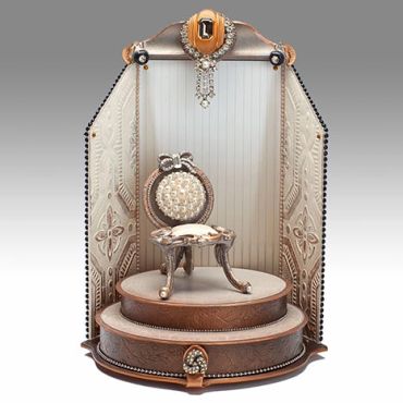 Ornate decorative display resembling a miniature stage with a chair.