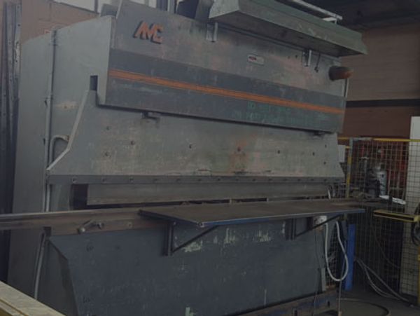 Industrial metal press brake machine in a workshop.