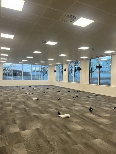 Empty office room with scattered socks on the carpeted floor.