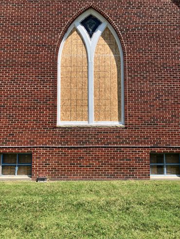 Outside view of West window openings boarded and sealed up. Top kite window was undamaged so it was 