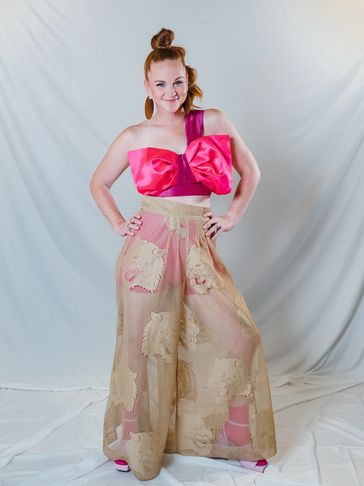 Closeup shot of a woman in pink and beige outfit posing