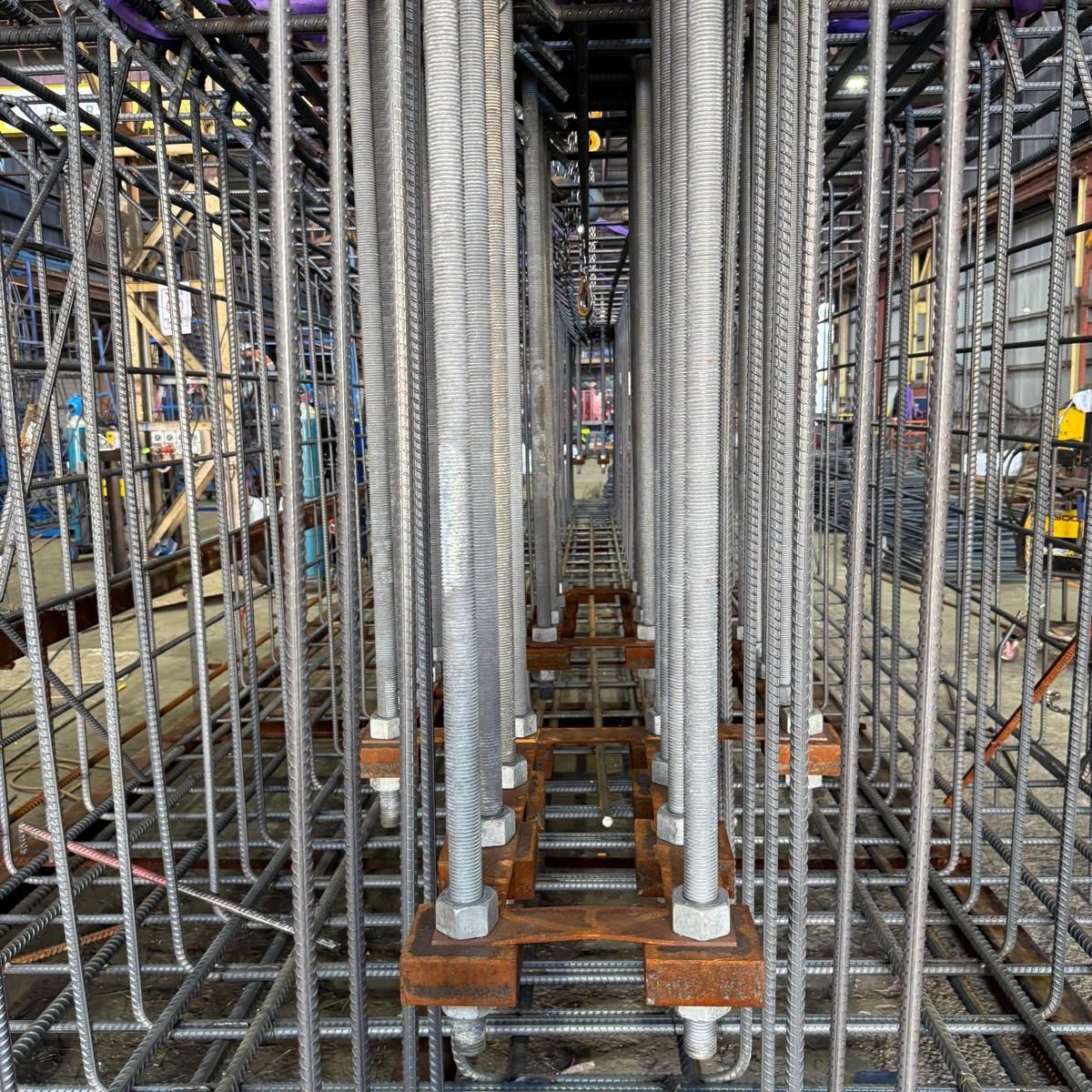 Close-up of steel rebar and threaded rods in a construction framework.