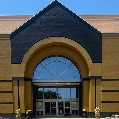 BIG gold building trimmed in black with 2 gold lion statues on each side of the entrance.