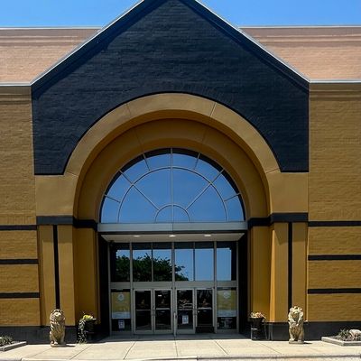 BIG gold building trimmed in black with 2 gold lion statues on each side of the entrance.