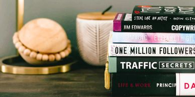 a pile of self improvement books on a desk Arcadia Search executive search and pr recruitment
