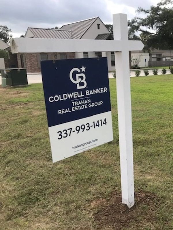 Coldwell Banker real estate sign on a lawn.