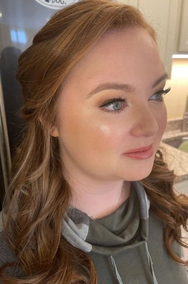 Close-up of a woman with styled hair and makeup.