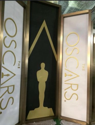 Oscar Awards signage with statues and gold lettering.