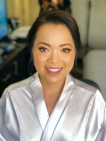 Smiling woman with brown eyes in a white robe.