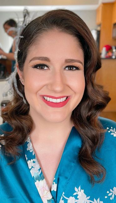 Close-up of a smiling woman with brown hair and teal floral robe.