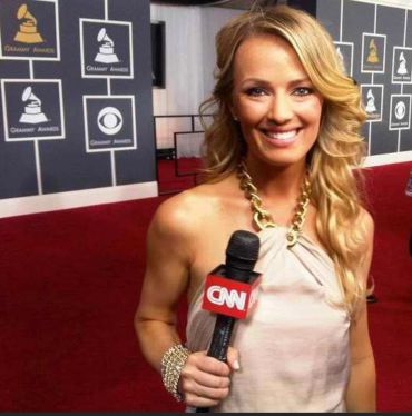 Woman smiling with a CNN microphone at the Grammy Awards.